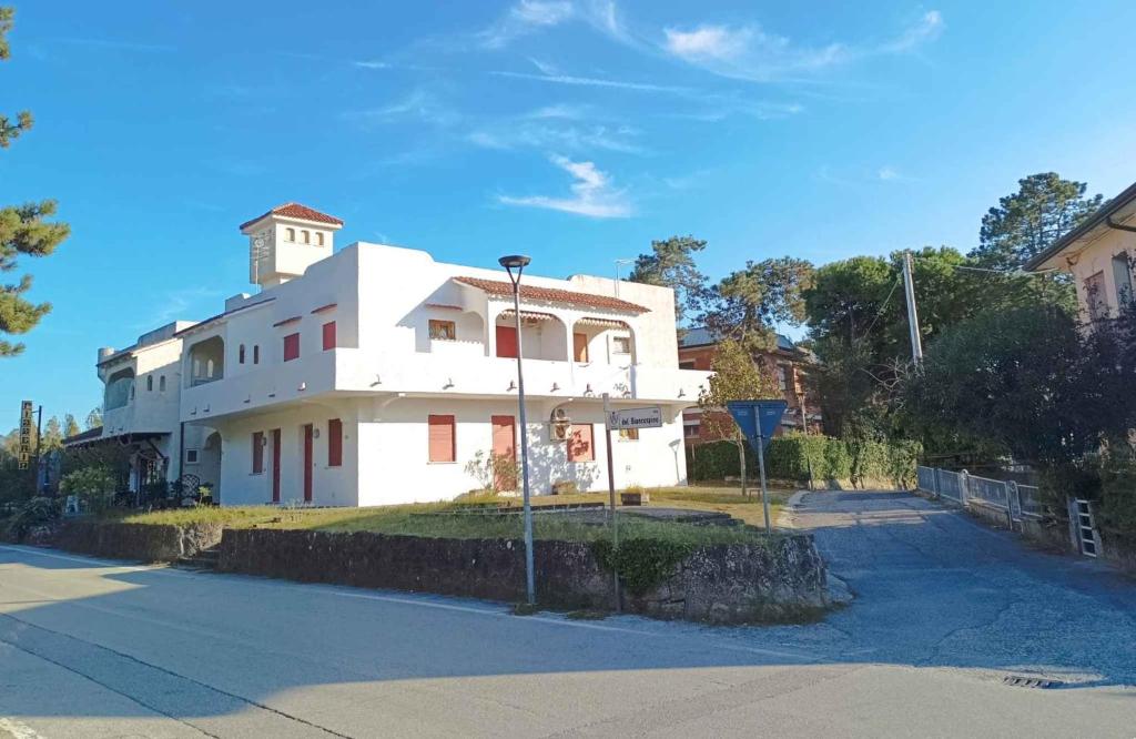 a white building with a clock tower on top of it at Apartments in Rosolina Mare 25092 in Rosolina Mare