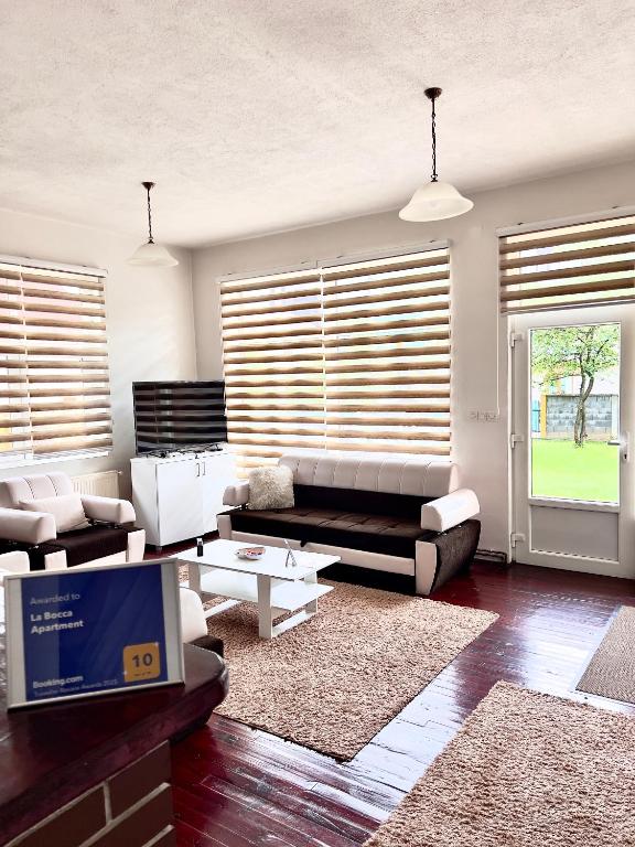 a living room with a couch and a table at La Bocca Apartment - Sarajevo Airport, Private Parking, 2 ACs in Sarajevo