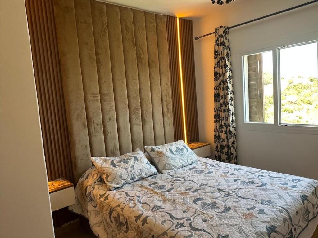 a bedroom with a large bed with a window at Appartement Bella Vesta JUSQU A 6 PERSONNES in Cabo Negro