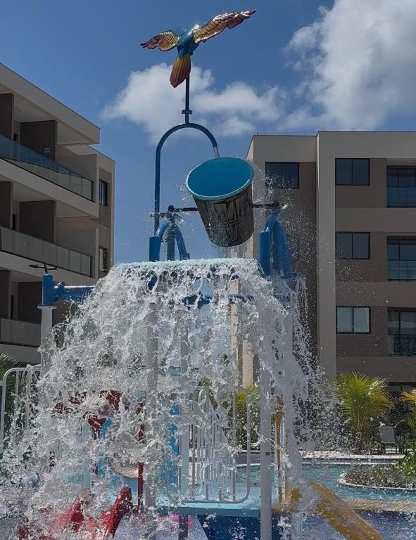 a water fountain with a bird flying over it at Muro Alto Comfort - Family Flat - 2 quartos in Ipojuca