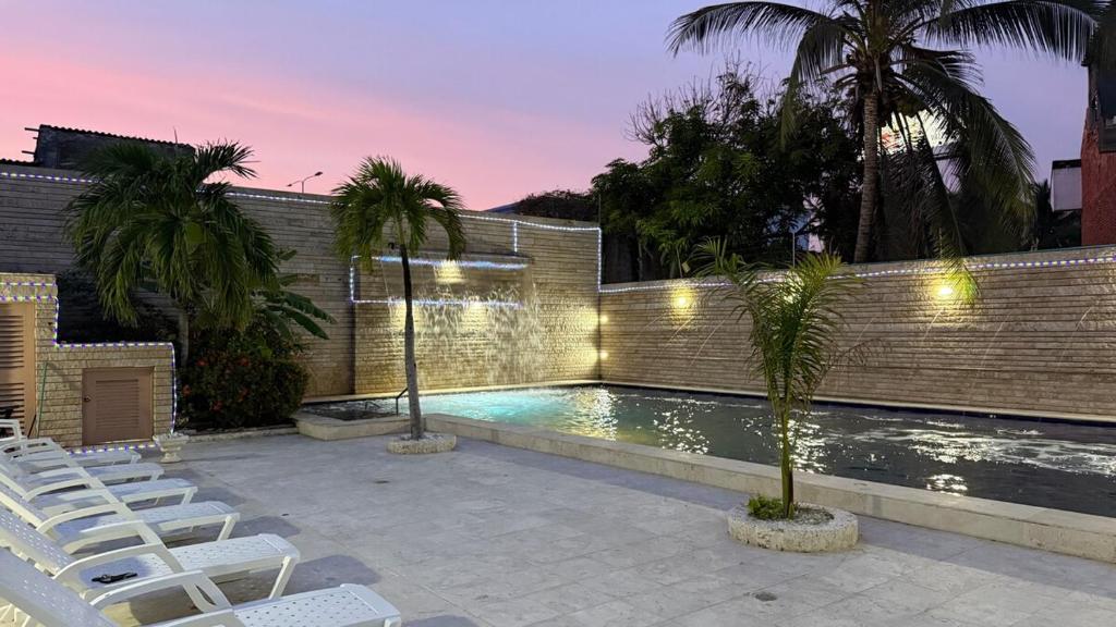 una piscina con sedie bianche e palme di Villa exclusiva junto al mar en Cartagena a Cartagena de Indias