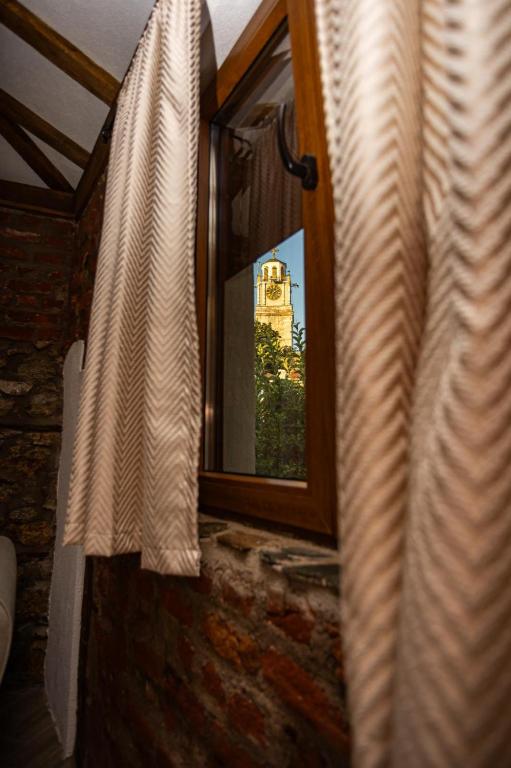 a window with a view of a building in the background at Modern Clock Tower Apartments in Bitola