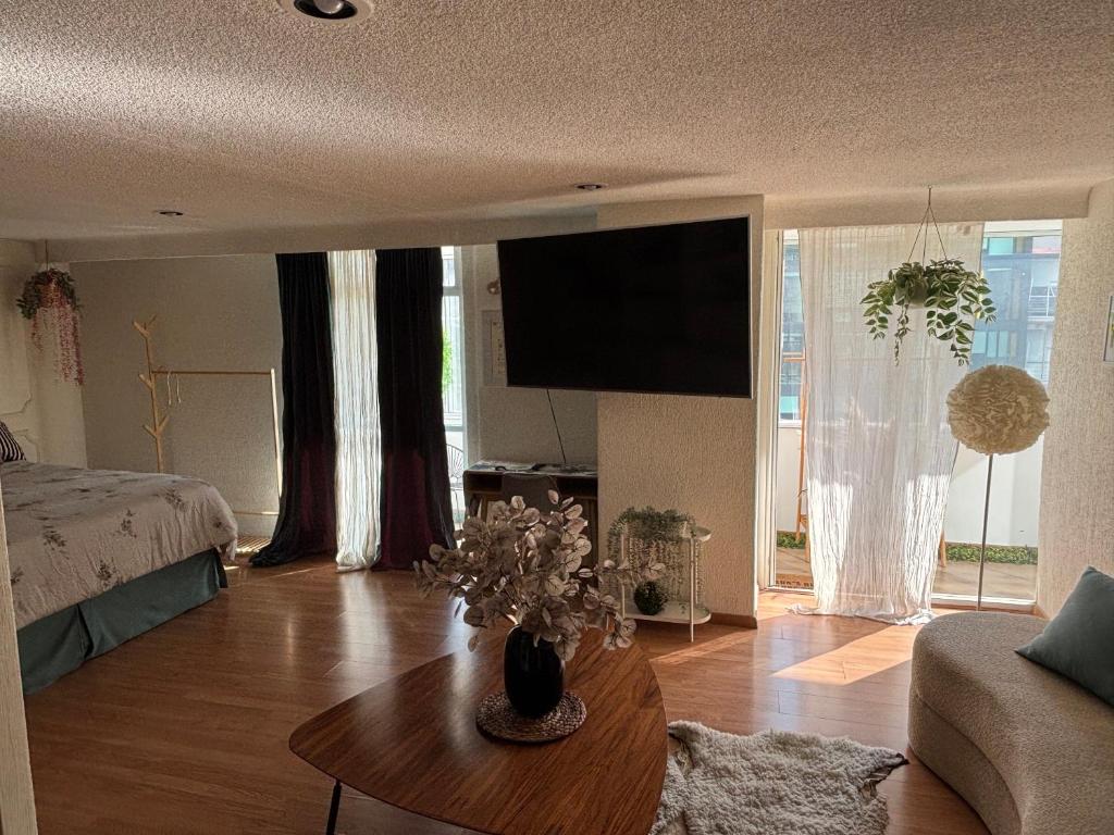 un soggiorno con letto e tavolo con fiori di Private room in Lomas, Polanco a Cedro