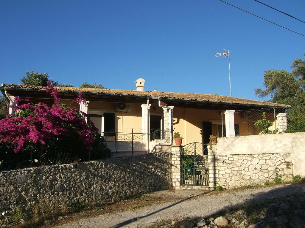 una casa con una pared de piedra y una valla en Katia Apartments, en Gáios