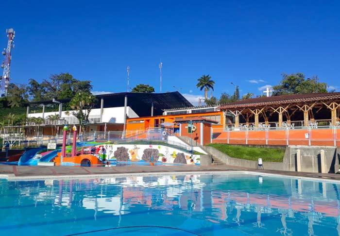 a large swimming pool with a building in the background at Parque de la Familia in Montenegro