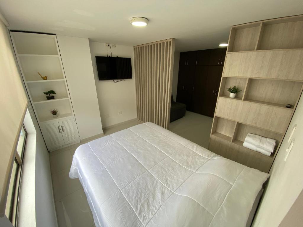 een slaapkamer met een wit bed in een kamer bij comodidades en el centro de la ciudad in Manizales