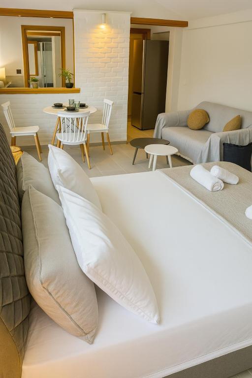 a bedroom with a bed with pillows and a living room at Marcia's Welcome House in Rafina