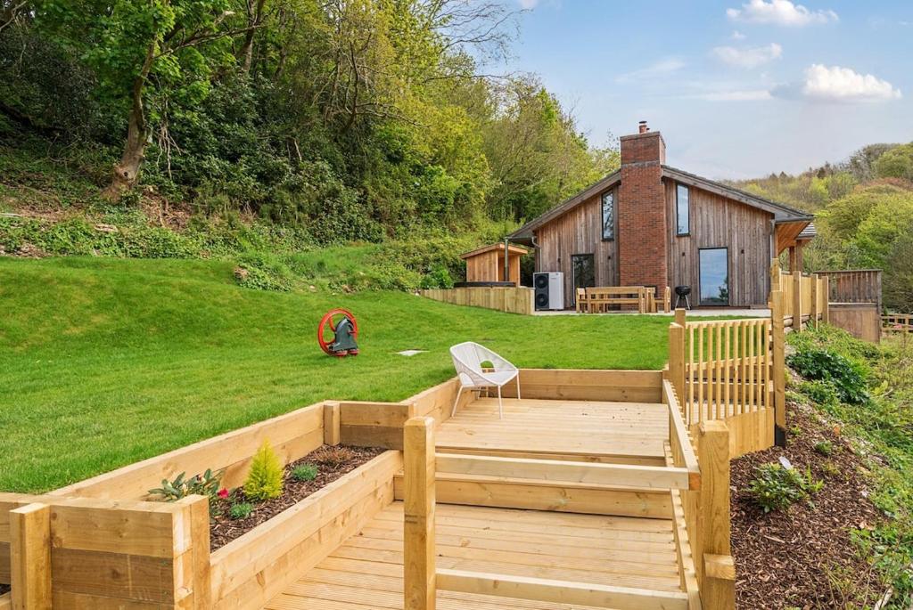 a backyard with a wooden deck and a house at Luxury secluded coastal retreat - With hot tub in Ilfracombe