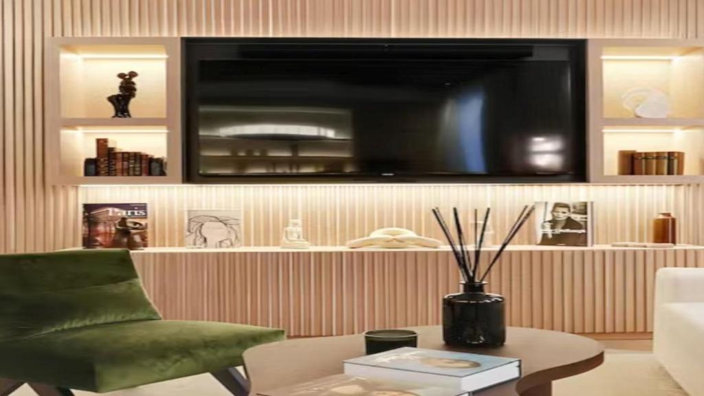 a living room with a green chair and a tv at Ski Chalet Stubenbach Lech in Oberlech