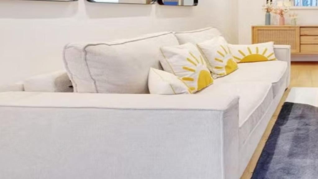 a white couch with pillows on it in a living room at Alpine Casa Vacanze Domenion Livigno in Livigno