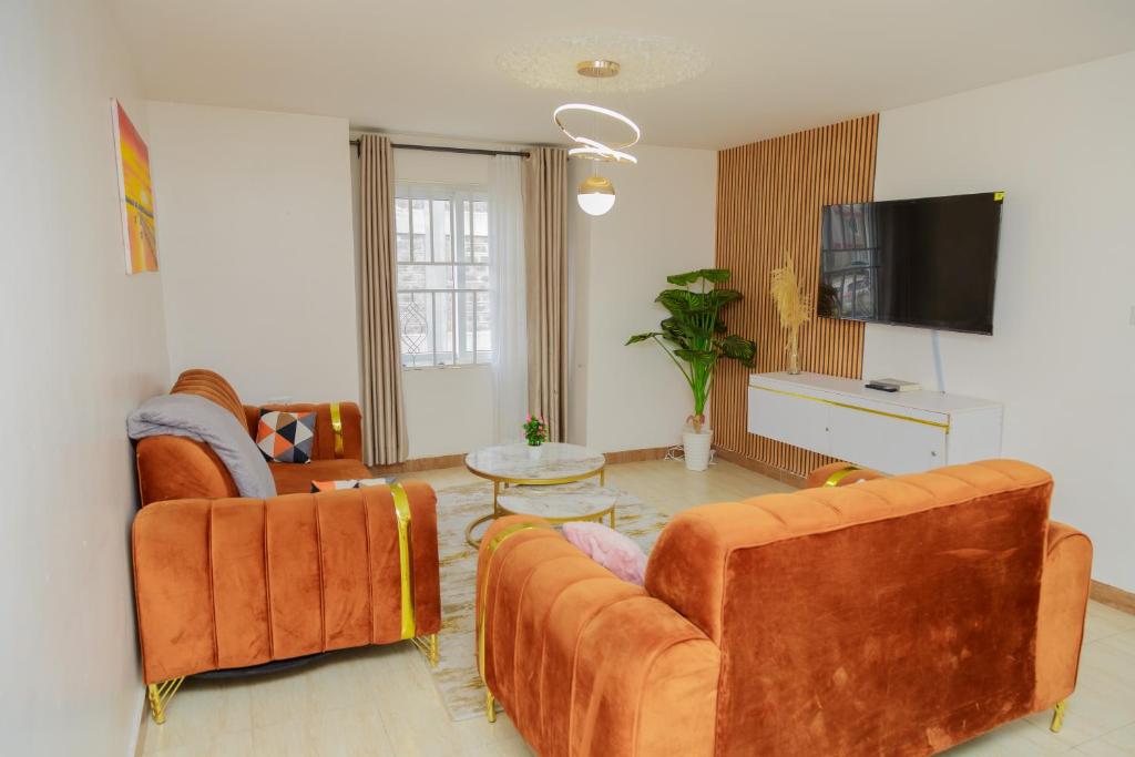 a living room with two couches and a tv at Perfect Stay for All Near Malls Attractions Free Parking in Ongata Rongai 