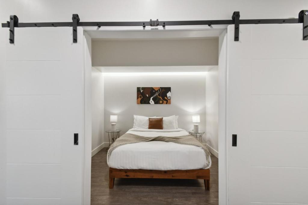 a bedroom with a bed through a sliding door at Southwestern Charm | Espadin LoHi in Denver