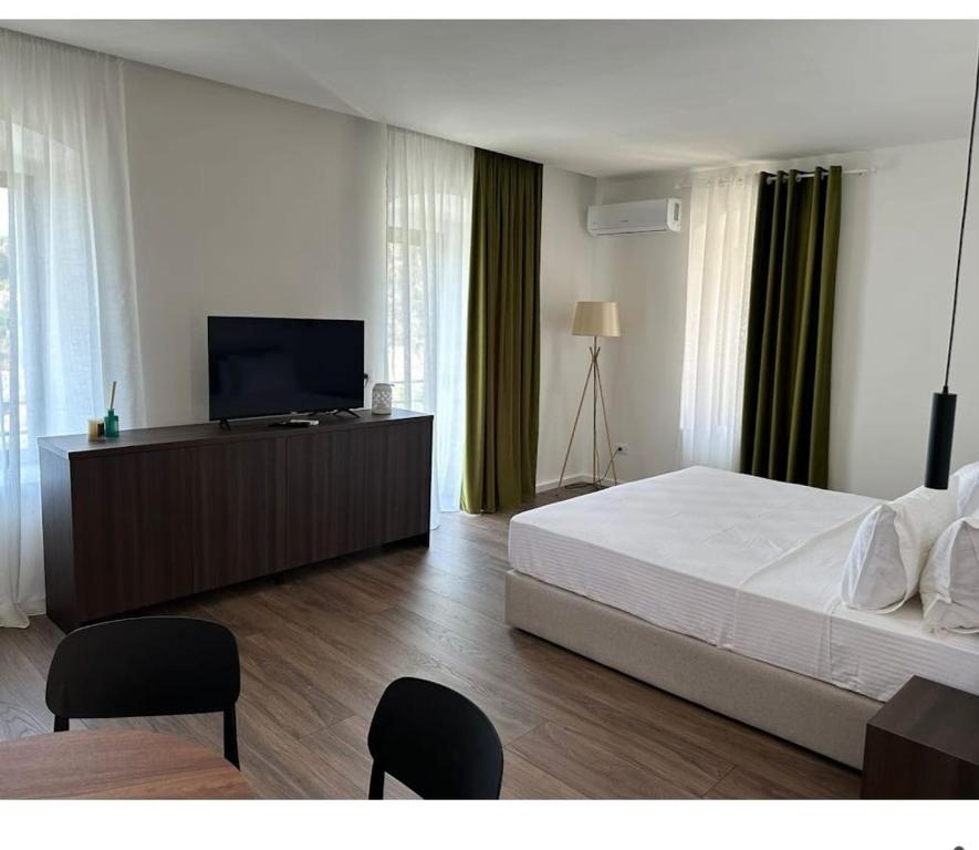 a bedroom with a bed and a flat screen tv at Milo's Villa in Dhërmi