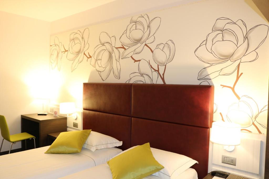a bedroom with a bed with a flower mural on the wall at Hotel Villa Nabila in Reggiolo