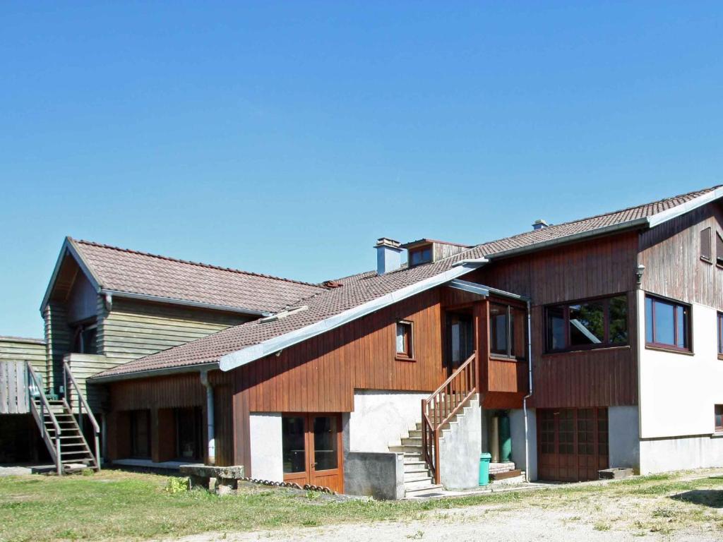 a wooden house with a staircase in front of it at Gîte familial avec salle de jeux, cheminée, terrasse et proche de sites touristiques - FR-1-589-186 in Pierrefitte