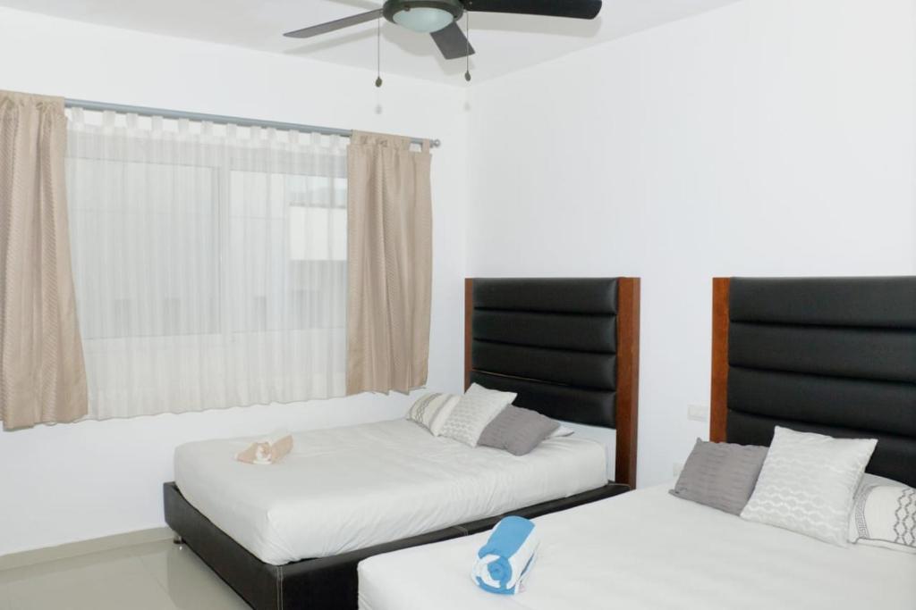 ein Schlafzimmer mit zwei Betten und einem Deckenventilator in der Unterkunft Grand Blue Playa in Playa del Carmen