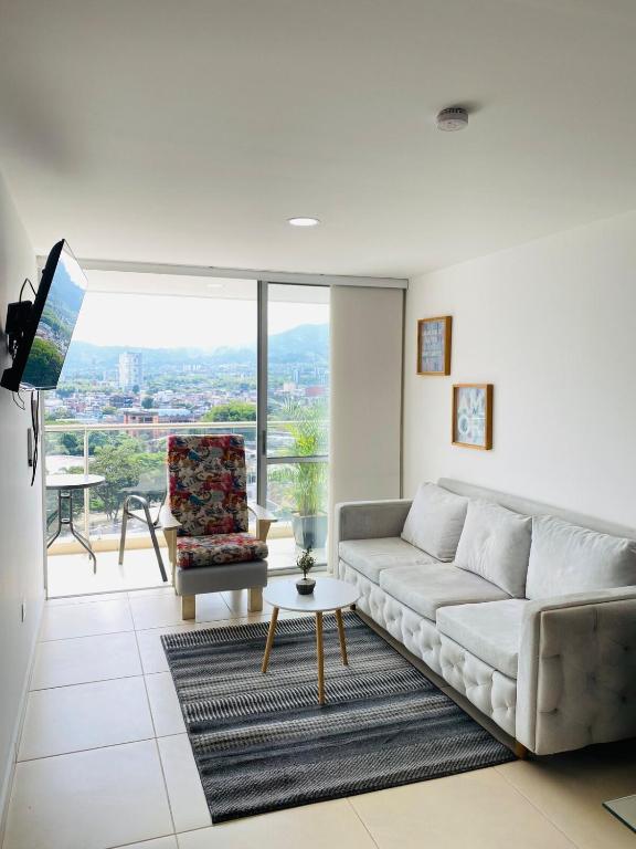 a living room with a couch and a table at La vida es bella Hermoso Apto Acogedor con Piscina in Dosquebradas