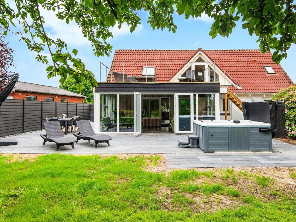a backyard patio with a table and chairs at 4 star holiday home in Henne in Henne