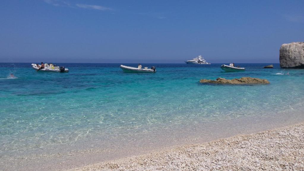 a group of boats in the water on a beach at Casa Purple in Cala Gonone