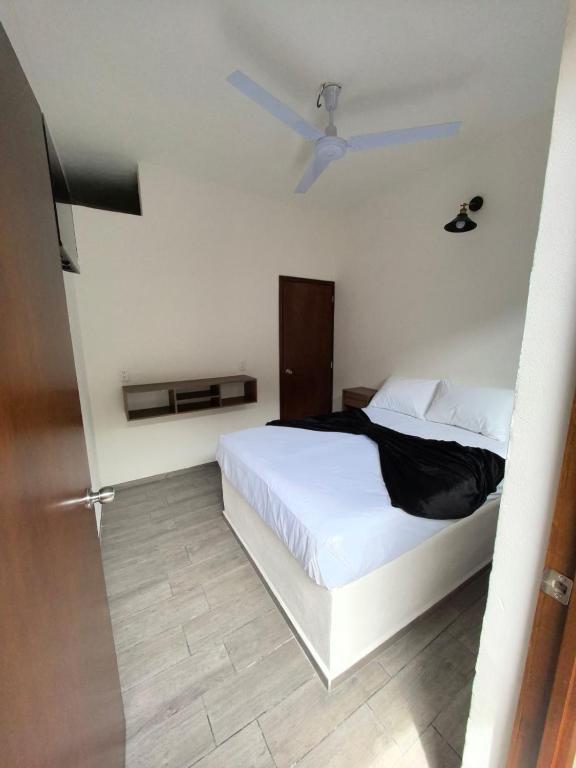 a bedroom with a white bed and a ceiling fan at Hotel Boutique Luz de Luna in San Blas
