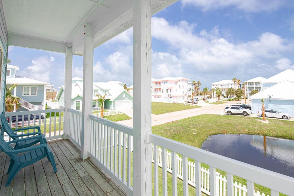 a porch with a blue chair and a view of the water at Blue Fin House- Pet Friendly & Boardwalk to the Beach! in Mustang Beach
