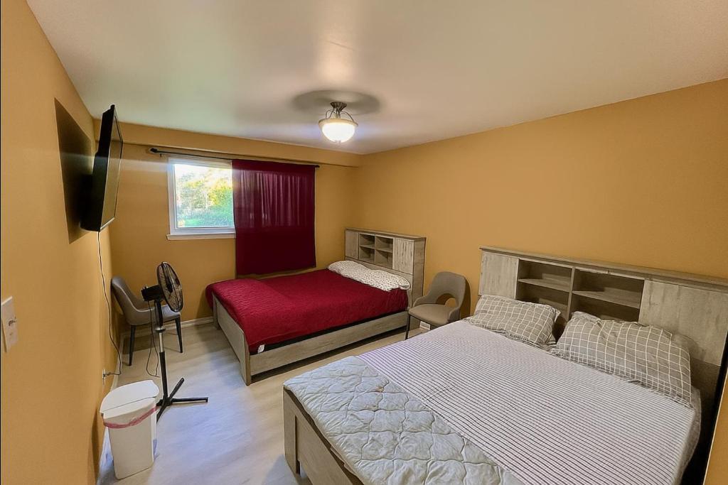a bedroom with two beds and a television in it at Dar-02 Private Room in Brampton