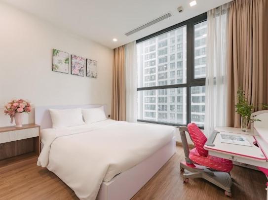 a white bedroom with a large white bed and a desk at Delux Studio In City Center With Gym, Swimming Pools And A Private Walking Lake in Hanoi