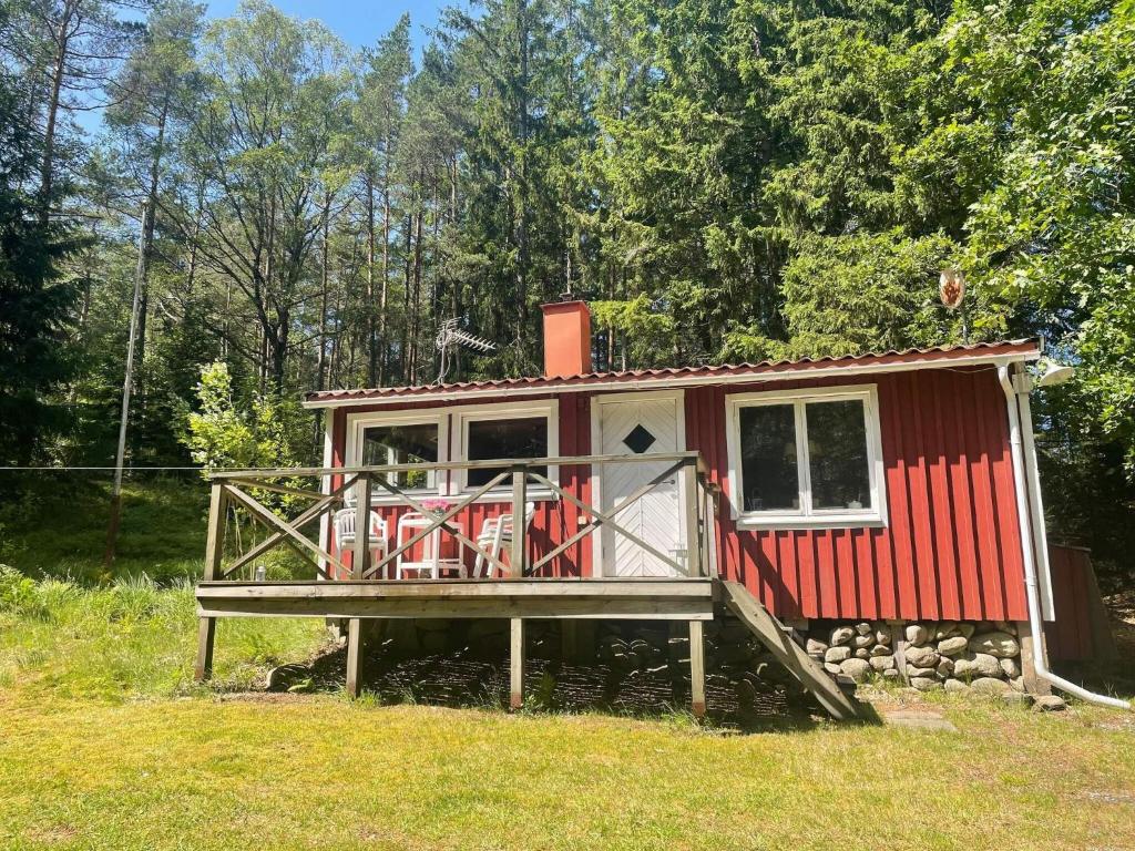 a red tiny house with a large deck at Peaceful Cabin near Furufjall Trail in Spekeröd