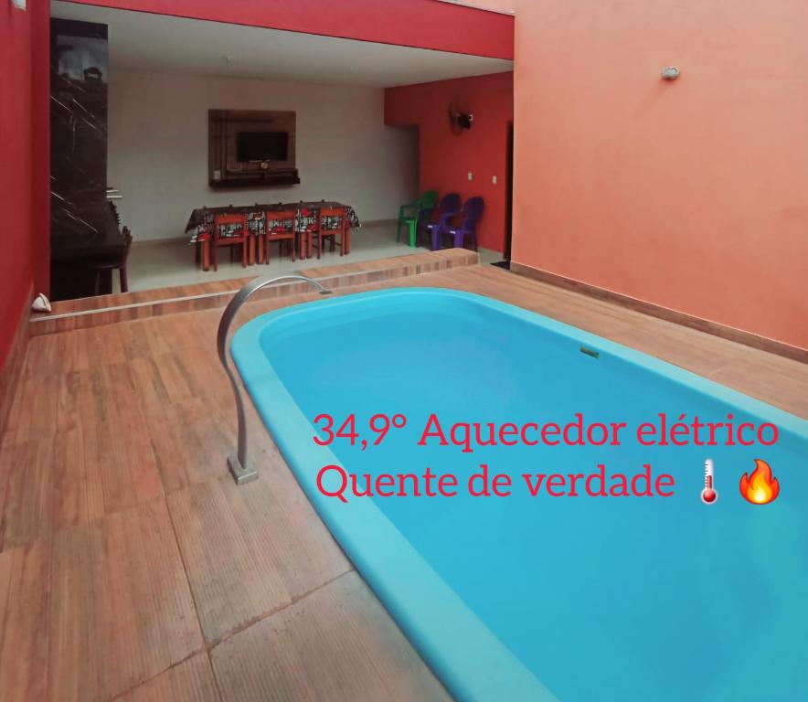 a swimming pool in a living room with a table at Casa Nova temporada piscina aquecida 24hs in Olímpia
