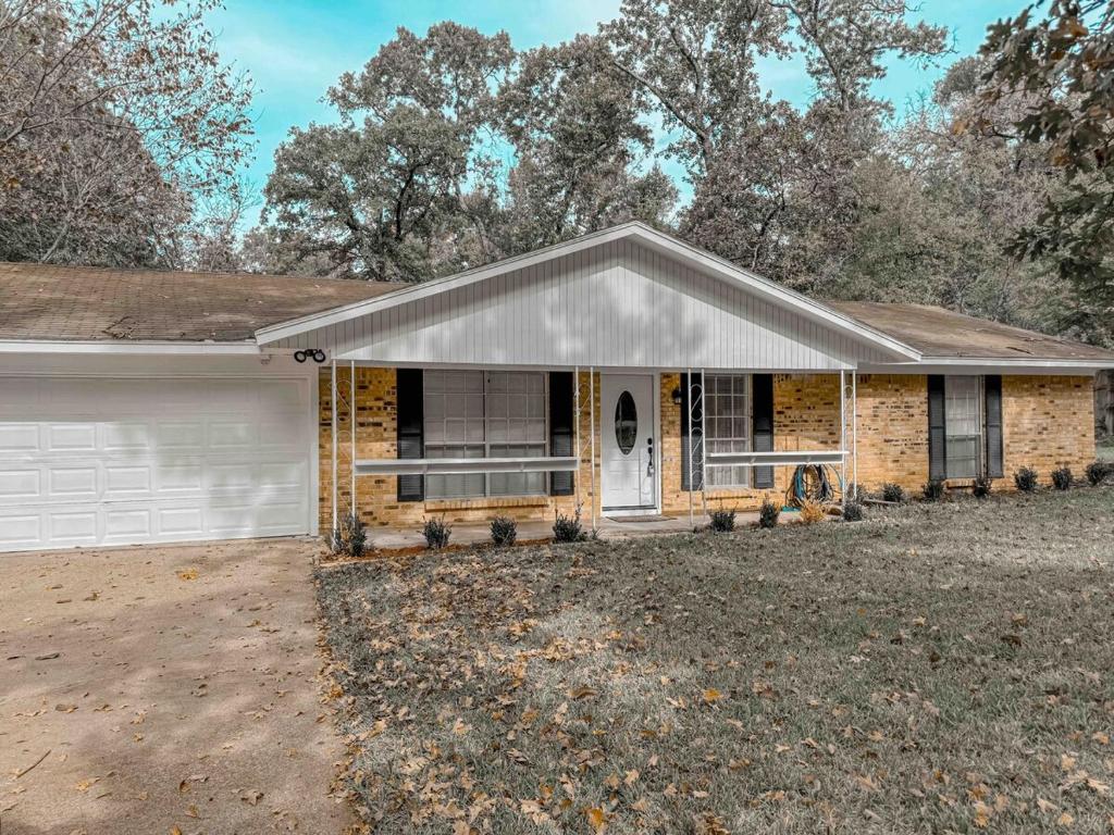 ein Backsteinhaus mit einer weißen Garage in der Unterkunft Vintage Family House in Lufkin