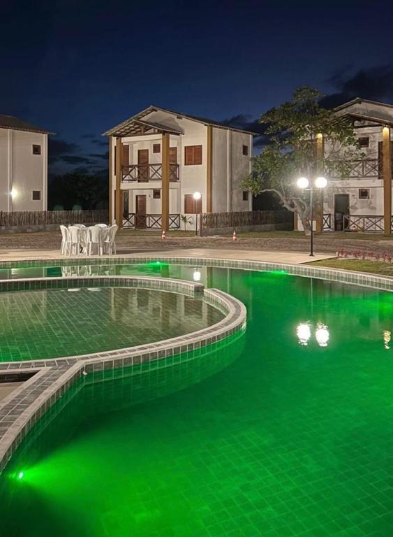 a pool with green water in front of a house at Casa OÁSIS ATINS Cond Village Buna in Atins