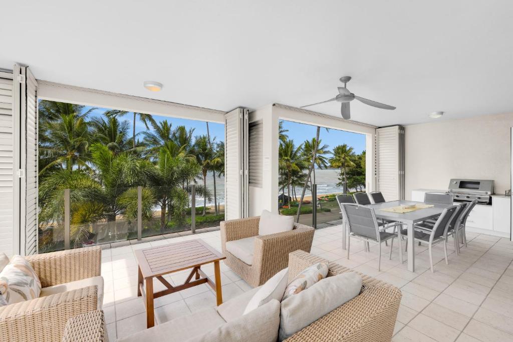 un soggiorno con un divano, sedie e un tavolo di Turquesa Tides - Beachfront Resort Living a Palm Cove