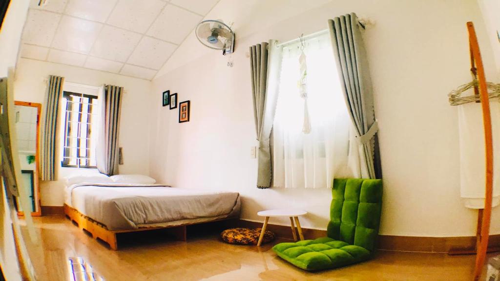 a bedroom with a bed and a chair and a window at Yến Homestay in Phước Hậu