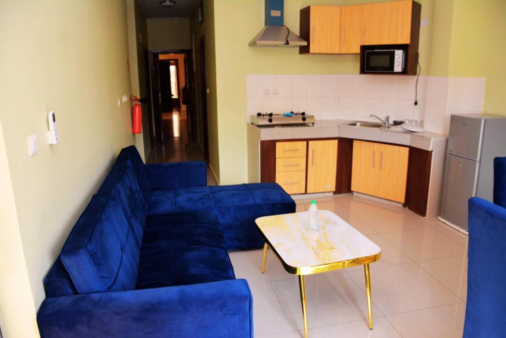 a living room with a blue couch and a table at Résidence Romacy, appartement 2 chambres avec balcon à Ahala, quartier résidentiel de Yaoundé in Yaoundé