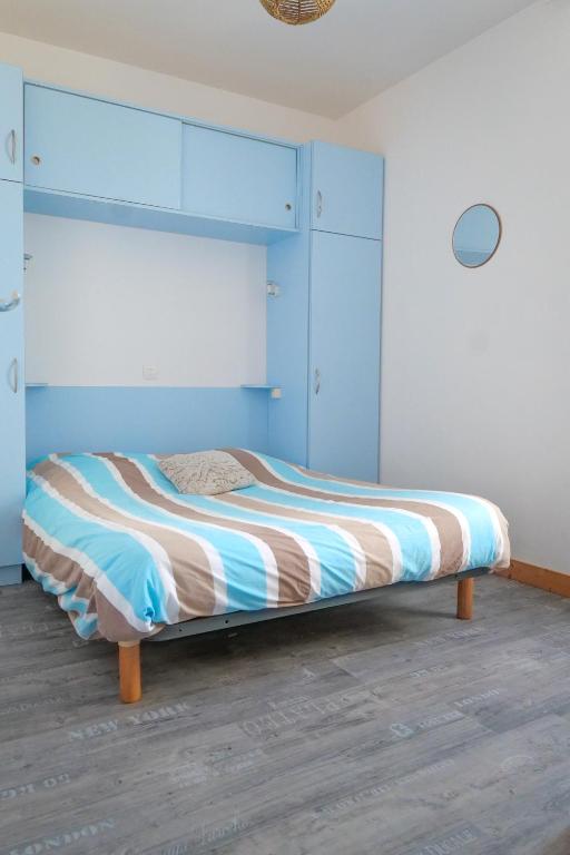 une chambre avec un lit avec une tête de lit bleue dans l'établissement Maison souplex avec patio aux sables - 4 personnes, à Les Sables-dʼOlonne