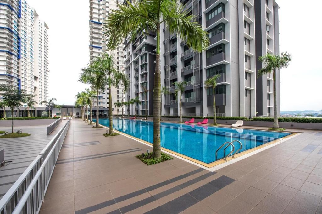 ein Swimmingpool mit Palmen und Gebäuden in der Unterkunft 3room condo Almyra Residence Puteri Bangi in Kajang
