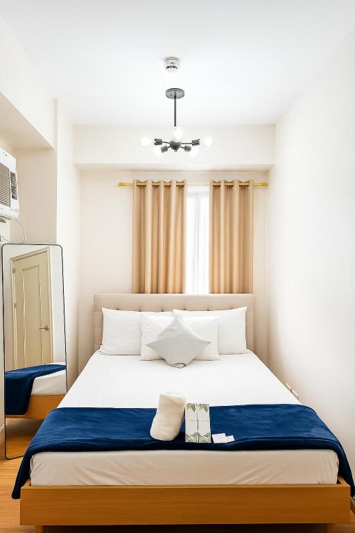 a bedroom with a large bed with a blue blanket at Camella Northpoint in Davao City