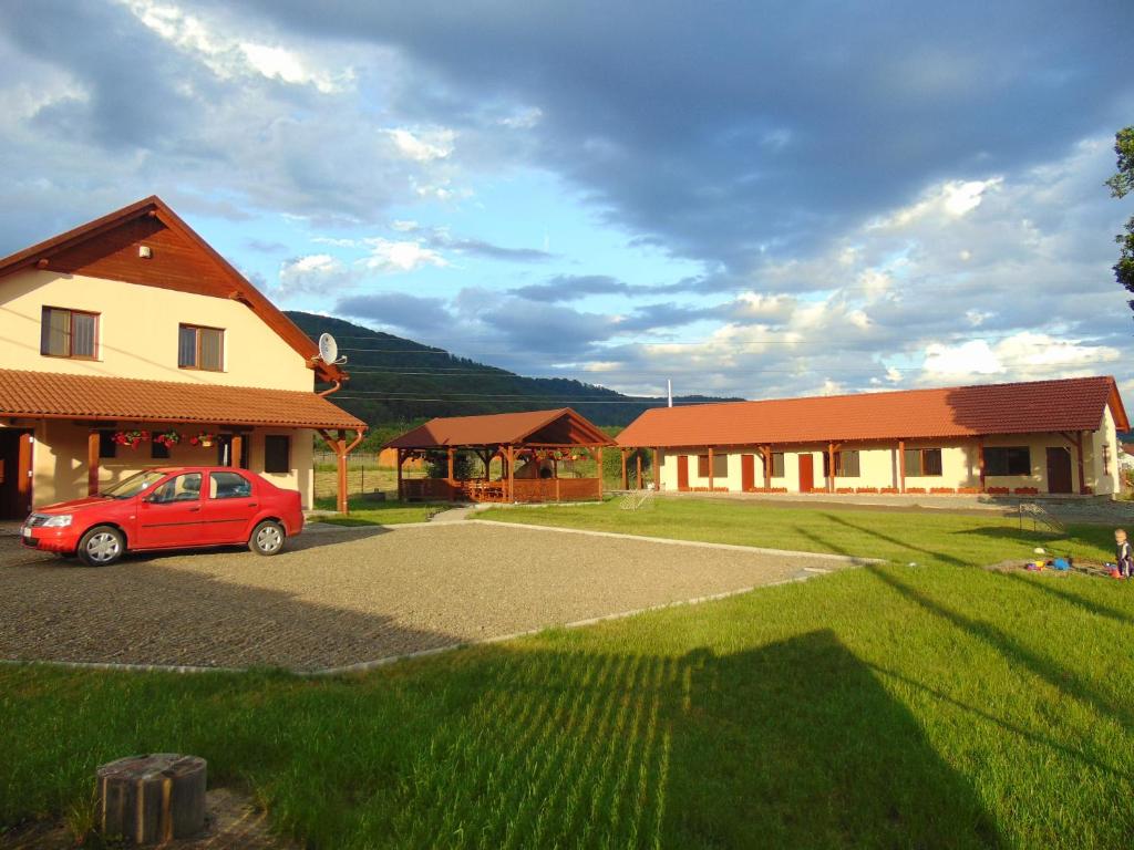 a red car parked in front of a house at Casa Loksi in Sovata