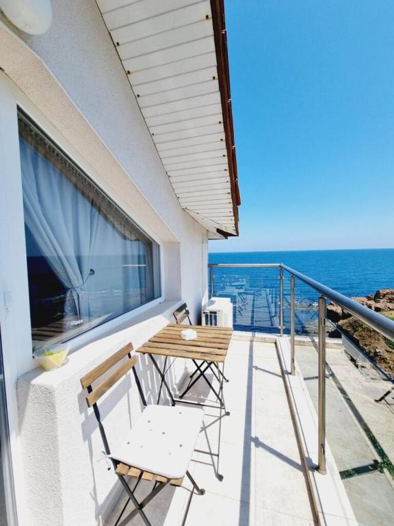 a balcony with two chairs and a table and the ocean at Casa DELL'ARTE in Ahtopol