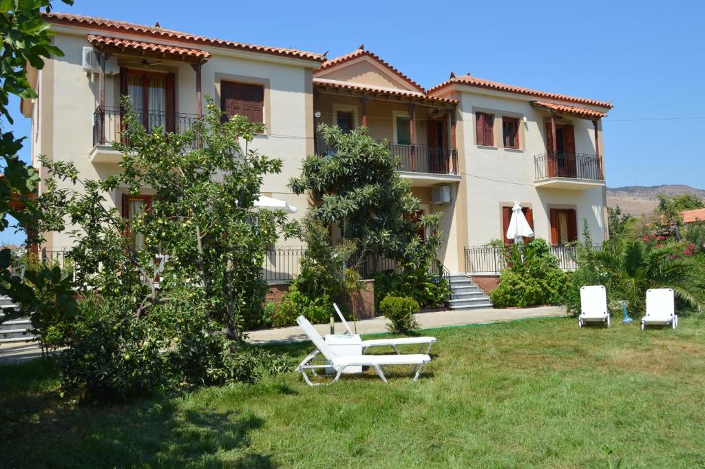 a house with two lawn chairs in the yard at Mr. Greek Villa in Petra