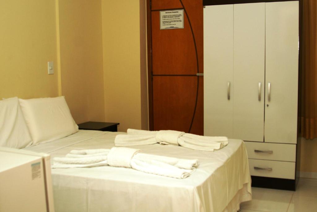 a bedroom with a bed with towels on it at Hotel Columbia in Luís Eduardo Magalhães