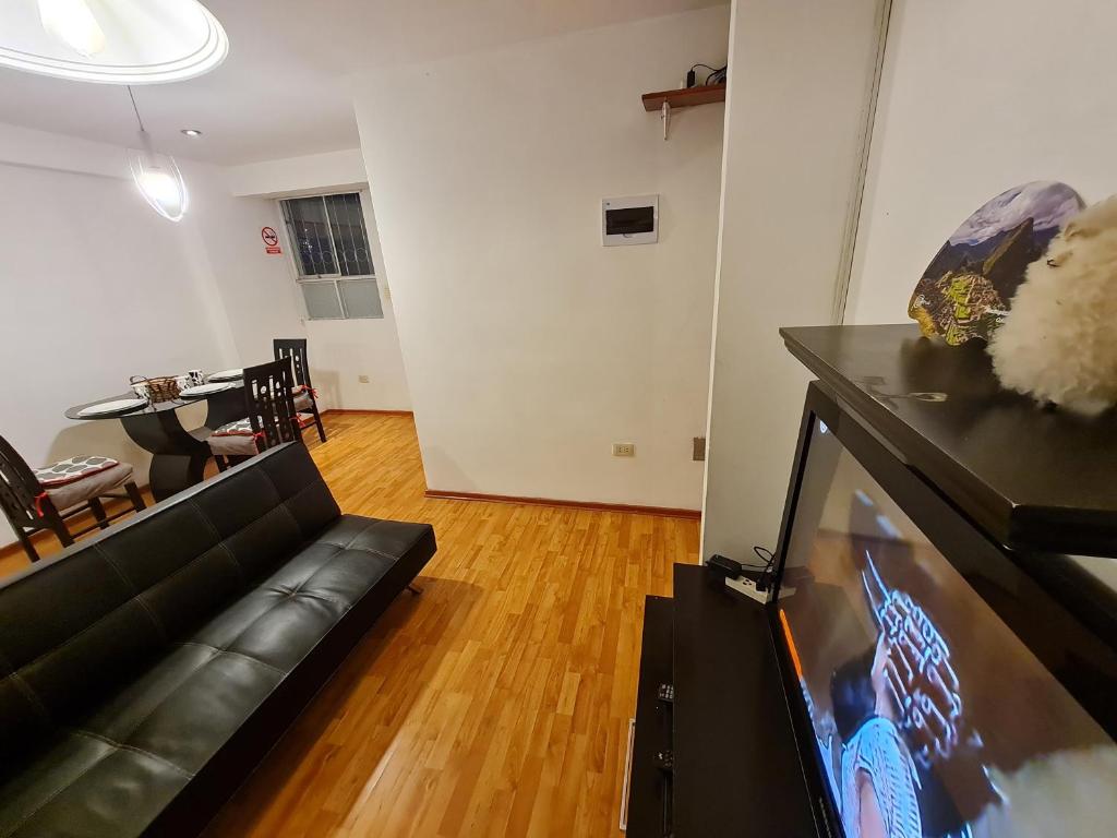 a living room with a couch and a flat screen tv at Kallpa in Cusco