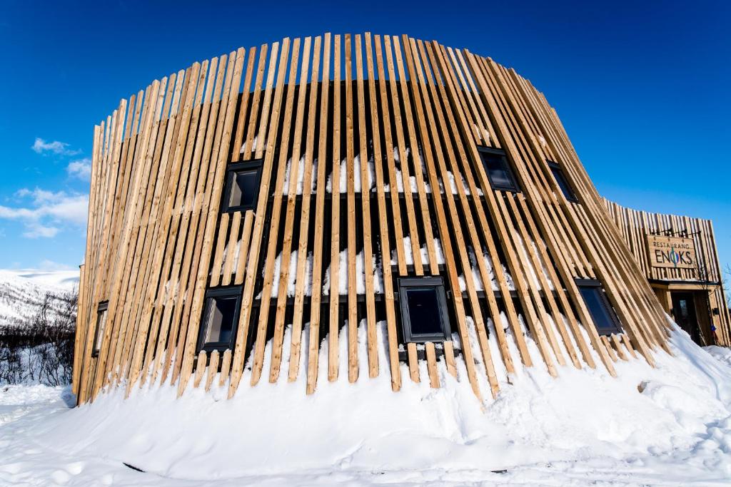 un edificio in legno è coperto di neve di Enoks i Láddjujávri a Nikkaluokta