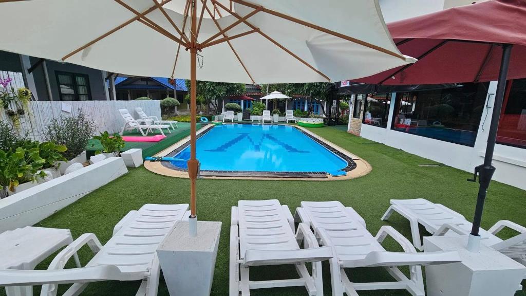 a group of chairs and an umbrella next to a pool at Rage Fight Academy in Pattaya South