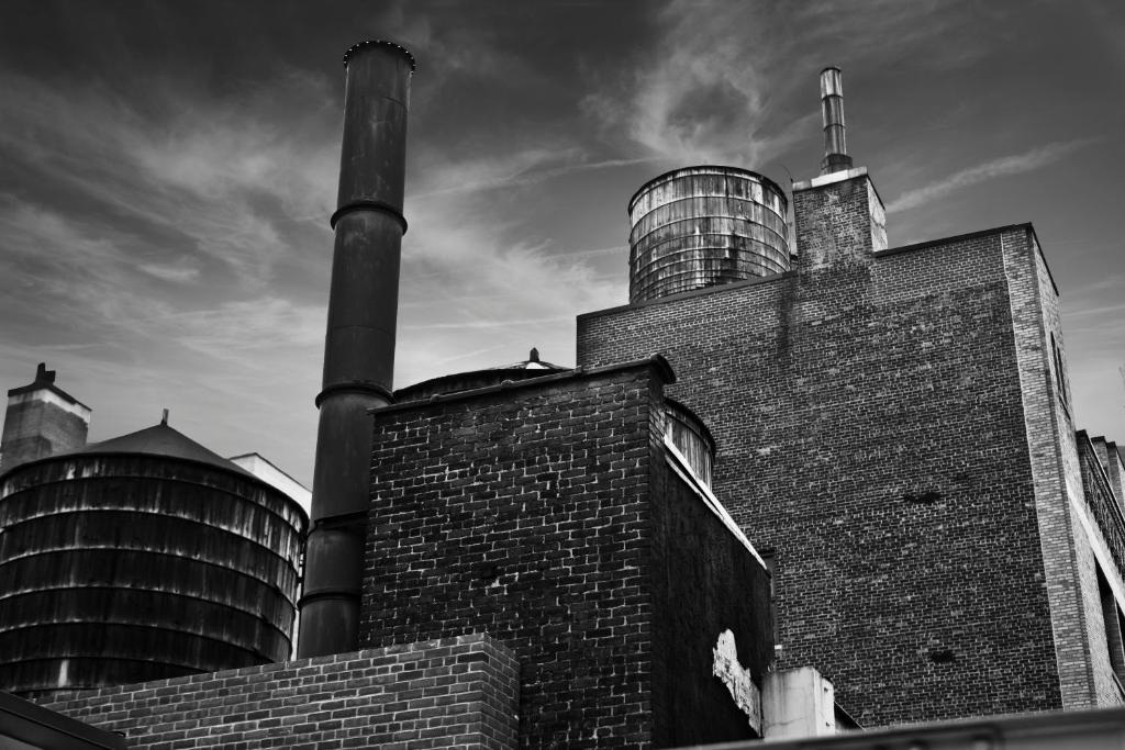 a black and white photo of a factory with two pipes at Refinery Hotel - New York in New York