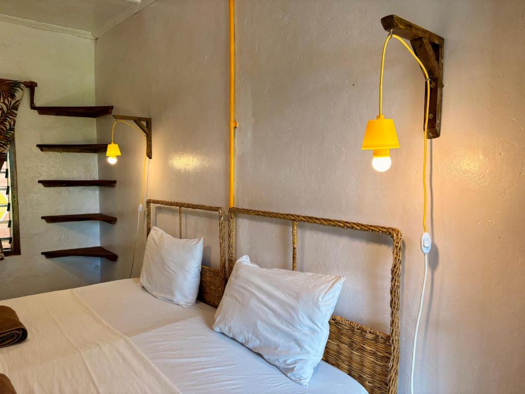 Camera con letto, 2 cuscini e lampada. di Hera Hostel Diani a Diani Beach