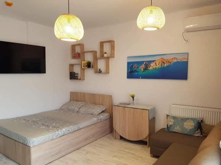 ein kleines Schlafzimmer mit einem Bett und einer Couch in der Unterkunft Saturn SunRise Studio in Saturn