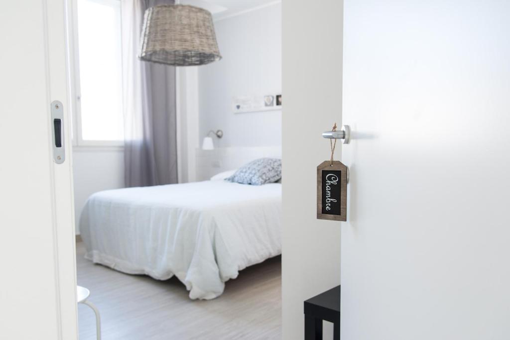 a white bedroom with a bed and a window at B&B Bucci 54 in Morciano di Romagna