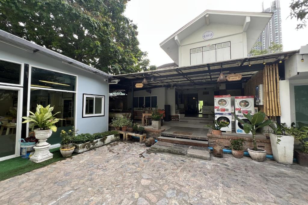 a house with potted plants in front of it at Orchid Hostel Near Bumrungrad hospital and Nana Market in Bangkok