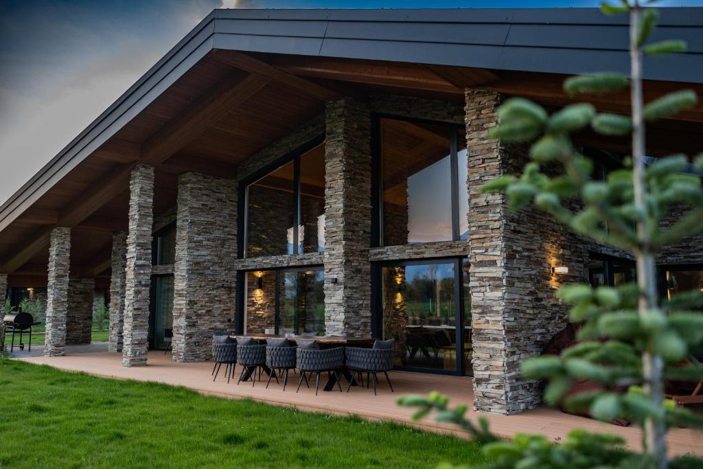 a building with chairs and tables on a patio at Hypnotic Thermal Villas in Banya